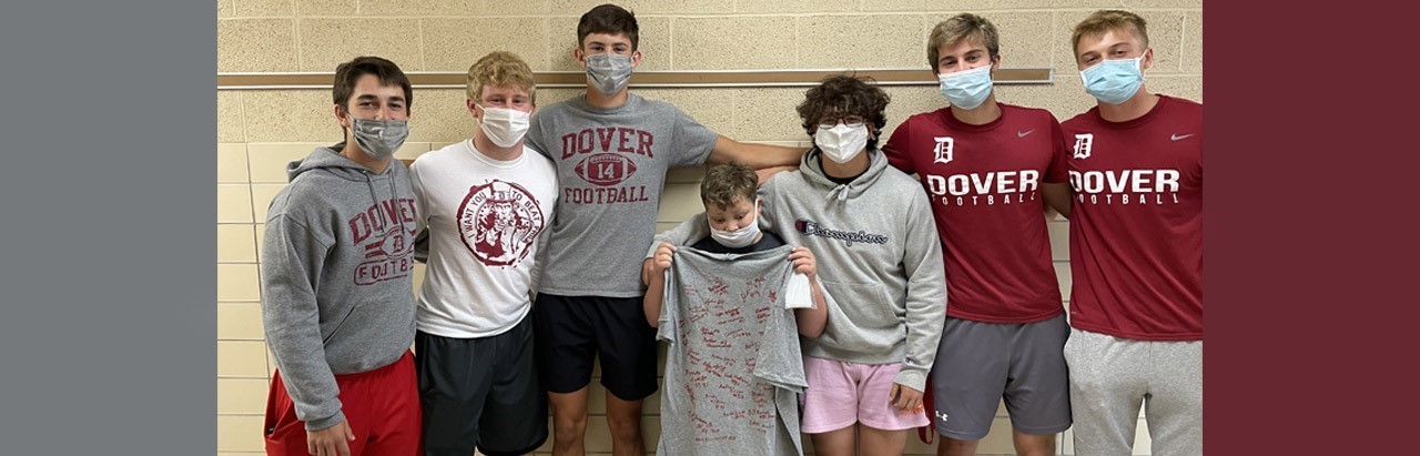 Middle School student get&#39;s a signed T-shirt from football players